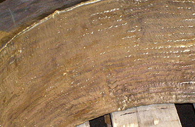 Deckscheibe / Ring ca. Ø950/650x270mm aus C45 (1.1730), im Stahlhammerwerk mit Bearbeitungszugabe roh nahtlos gewalzt mit US-Prüfung und 3.1B-Zeugnis, Innendurchmesser vorfräsen, vorwärmen, unter Temperaturhaltung Auftragsschweißung Alubronze CuAl8 ( 2.0981 ) DIN 17665 mehrlagig ca. 6mm, spannungsarm glühen, drehen auf Karussell, fertig bearbeiten auf CNC-Bohrwerk